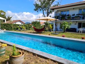 uma piscina em frente a uma casa em Appartement avec cuisine et grande piscine chauffée em Hendaye