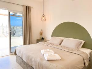 a bedroom with a large bed with two towels on it at La Ventana Hostel in La Ventana