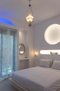 a bedroom with a white bed and a large window at Villa Iliousa Grand in Psinthos
