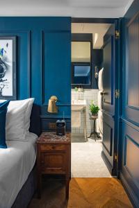 a bedroom with blue walls and a bed and a table at The Bull & Last in London
