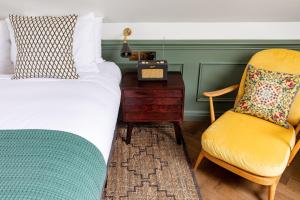 um quarto com uma cama, uma secretária e uma cadeira em The Bull & Last em Londres