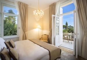 een slaapkamer met een bed en een kroonluchter bij Villa Amalia - Liburnia in Opatija