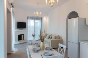 een witte woonkamer met een tafel en een bank bij Villa Iliousa Grand in Psinthos