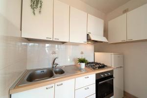 a kitchen with white cabinets and a sink and a stove at Da Angiolina in Marciana