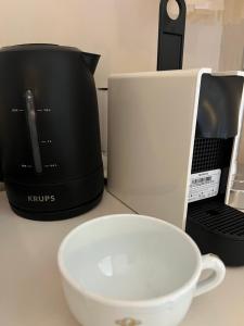 a microwave and a coffee maker and a bowl on a counter at L'ESCALE Chambres et table d'hôtes in Verdun-sur-le-Doubs