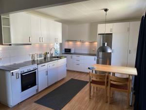 a kitchen with white cabinets and a wooden table at Hotel Lapland River in Pajala
