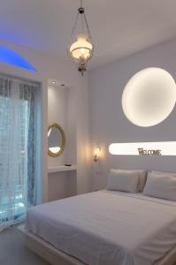 a white bedroom with a large bed and a chandelier at Villa Iliousa Grand in Psinthos