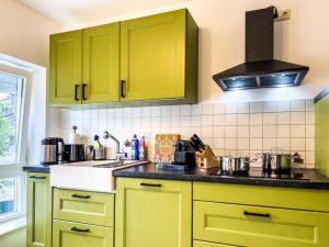 cocina con armarios amarillos y fogones en STYLISCHE ZENTRALE WOHNUNG MIT KÜCHE UND PARKPLATZ IN SEITENSTRAẞE, en Deggendorf