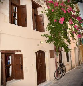 ein Fahrrad neben einem Gebäude mit Blumen geparkt in der Unterkunft Atrium house in Rethymno