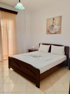 a bedroom with a large bed with white sheets at Mussels apartments in Ksamil