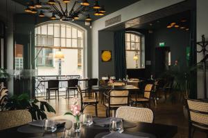 a restaurant with black walls and tables and chairs at Neiburgs Hotel in Riga