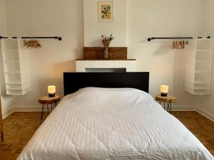 1 dormitorio con 1 cama con 2 velas en 2 mesas en Gezellige villa met open haard en zonnige tuin., en Doische