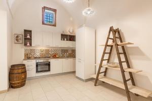 a kitchen with white cabinets and a wooden ladder at Le Mule Suite and Rooms - Specchia in Specchia +21 photos