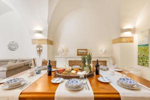ein Esszimmer mit einem Tisch mit Essen drauf in der Unterkunft Le Mule Suite and Rooms - Specchia in Specchia