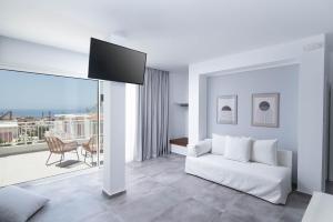 Sea View Luxury Villa White in Blue في ماتالا: غرفة معيشة مع أريكة بيضاء وتلفزيون
