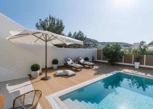 Sea View Luxury Villa White in Blue في ماتالا: مسبح مع كراسي ومظلة على فناء