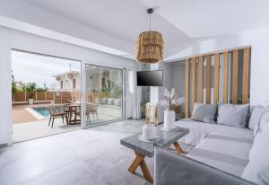 een woonkamer met een bank en een tafel bij Sea View Luxury Villa White in Blue in Matala