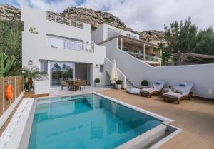 a villa with a swimming pool and a house at Sea View Luxury Villa White in Blue in Matala