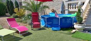 a backyard with a hot tub and chairs and an umbrella at LES ORCHIDEES Ch Hôtes B&B 14 personnes Jaunay-Clan in Jaunay-Clan
