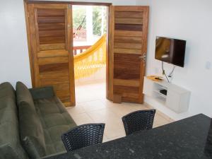 uma sala de estar com um sofá e uma televisão em Pousada Brisas em Jijoca de Jericoacoara