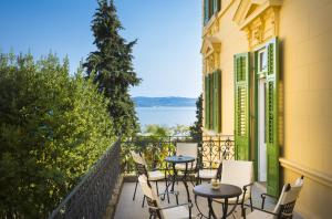 a balcony with tables and chairs and a view of the water at Apartments Atlanta - Liburnia in Lovran