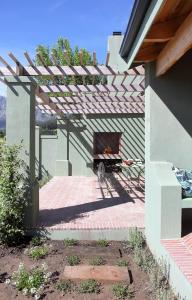 a brick patio with a fireplace in a house at Jardin de la Ferme in Franschhoek