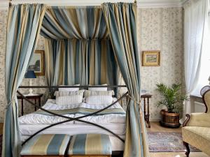 um quarto com uma cama de dossel e cortinas azuis em Nääs Slott em Floda