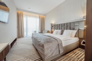 a bedroom with a large bed and a large window at Elements Hotel&Spa in Świeradów-Zdrój