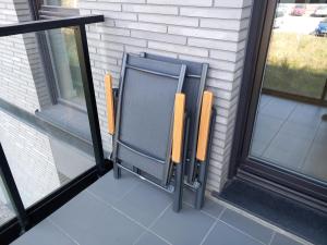 a chair sitting on a porch next to a window at Old Town Nadmotławie - Sauna & Gym I 10min deptak in Gdańsk