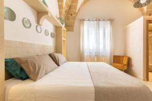 1 cama blanca grande en una habitación con ventana en Le Mule Suite and Rooms - Specchia, en Specchia