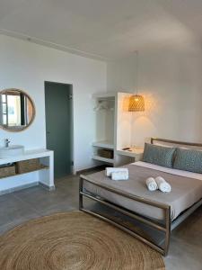 sypialnia z łóżkiem, umywalką i lustrem w obiekcie Elysium Apartments Corfu w mieście Paleokastritsa