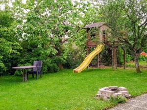 un parco giochi con scivolo in un cortile di Chez l'Eveline a Les Bois