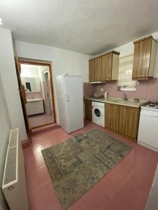 eine Küche mit einem weißen Kühlschrank und Fliesenboden in der Unterkunft Budak Home in Nevşehir