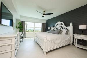 a bedroom with a white bed and a white dresser at Unit 103 Aruba - 3 Bedroom Ocean Front in Daytona Beach +36 photos