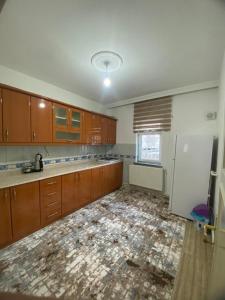 an empty kitchen with wooden cabinets and a white refrigerator at Budak Home in Nevşehir