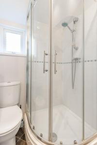 a bathroom with a shower and a toilet at Cromer Town Apartment 1 - Norfolk Holiday Properties in Cromer