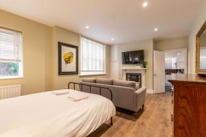 a bedroom with a bed and a couch and a television at Cromer Town Apartment 1 - Norfolk Holiday Properties in Cromer