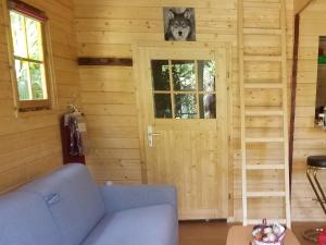 uma sala de estar com um sofá azul em frente a uma porta em Normandy cottage em Gagny