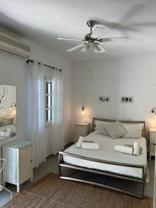sypialnia z łóżkiem i wentylatorem sufitowym w obiekcie Elysium Apartments Corfu w mieście Paleokastritsa