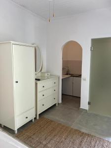 Jest to biały pokój z komodą i lustrem. w obiekcie Elysium Apartments Corfu w mieście Paleokastritsa
