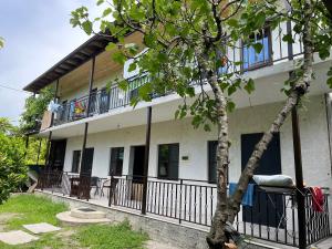 un bâtiment avec un arbre en face dans l'établissement Леон, à Gagra