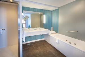 a bathroom with a tub and a sink and a mirror at Hotel Angela - Adults Recommended in Fuengirola
