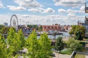 een uitzicht op een stad met een reuzenrad bij Old Town - River Point by Welcome Apartment in Gdańsk