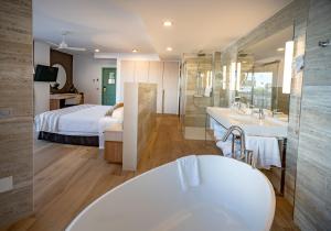 a bathroom with a bed and a tub and a sink at Hotel Angela - Adults Recommended in Fuengirola