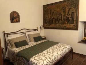 1 dormitorio con 1 cama con una pintura en la pared en La casa della sirena en SantʼEufemia a Maiella