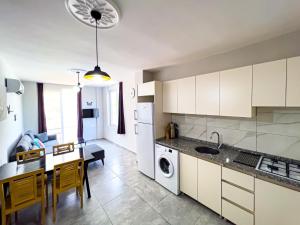 a kitchen and dining room with white cabinets and a table at Just Dream Suites in Kaş