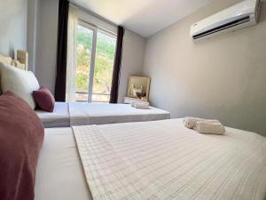 two beds in a room with a window at Just Dream Suites in Kaş