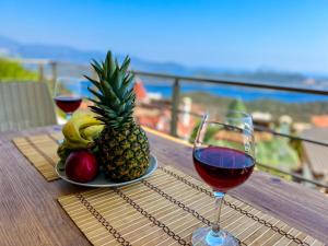 a table with a glass of wine and a plate of fruit at Just Dream Suites in Kaş