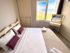 a bedroom with a bed with purple pillows and a window at Just Dream Suites in Kaş