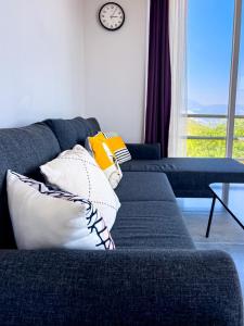 a living room with a couch with pillows and a clock at Just Dream Suites in Kaş